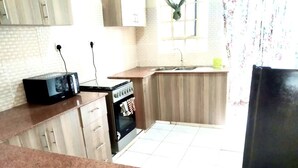 Una cocina con microondas, estufa y pileta.