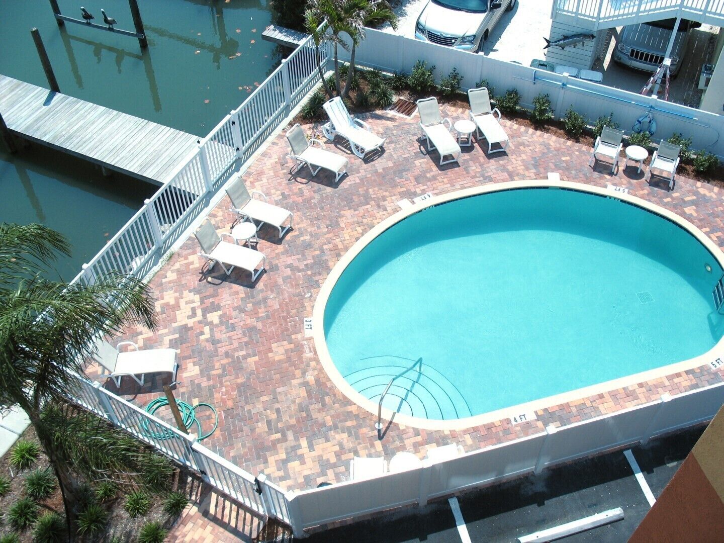 A rooftop pool with lounge chairs and a wooden deck.