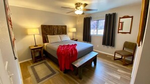 A hotel room with a bed, bedside lamps, a ceiling fan, a window with curtains, a wooden chair, and a rug. - #1 Casita Wild Mustang at the Catwalk, 2 BdRm Casita (Catron County)