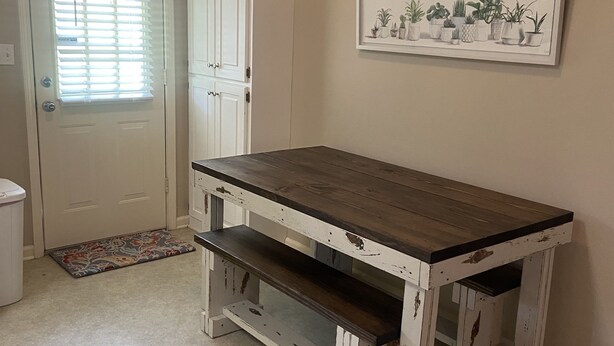 A room with a wooden table, a white door, a white cabinet, and a framed plant artwork on the wall. - Close to Vaught Hemingway and Swayze (Oxford)
