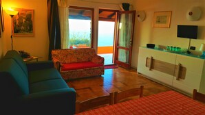 Ein Wohnzimmer mit einer Couch, einem Tisch und einer Küchenzeile.