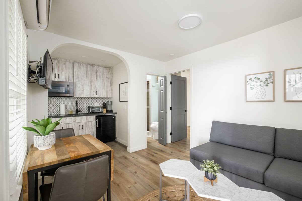 A modern apartment with a dining area, kitchen, and living room.