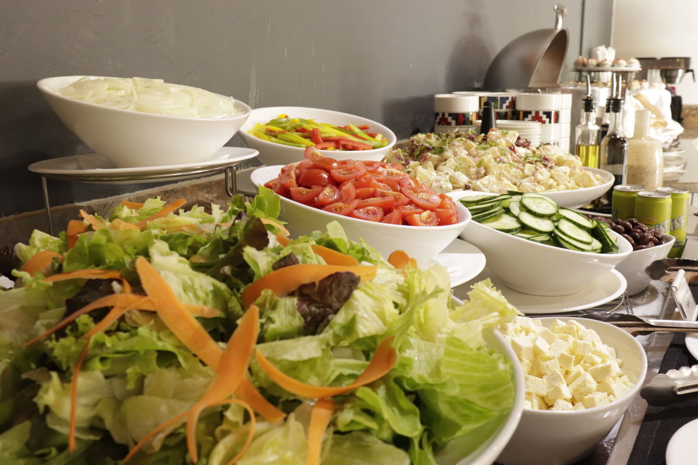 A buffet table with various salads and dishes.