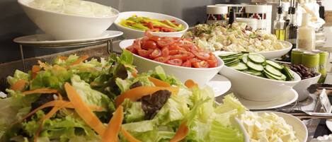 A buffet table with various salads and dishes.