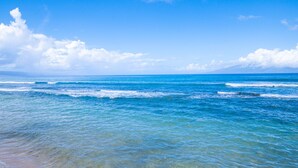 A beach with clear blue water and a distant mountain range. - Oceanfront 1bd condo with endless ocean views (Lahaina)