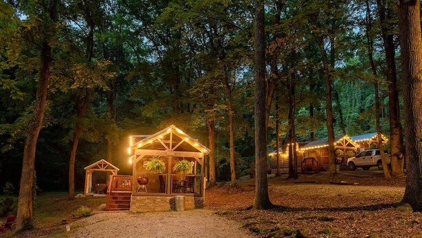 A cabin with a porch, a dining area, and a vehicle parked nearby. - Peggers Luxury Tiny Cabin at Lookout - Loaded (Chattanooga)