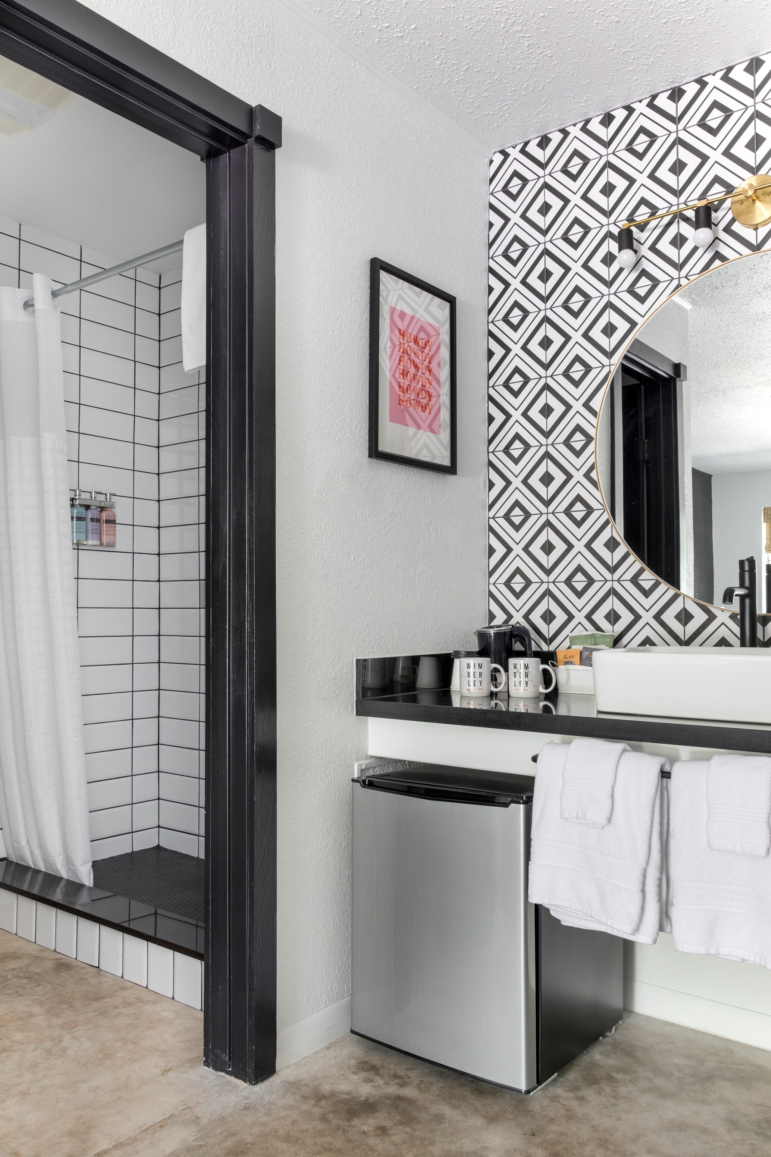 A bathroom with a shower, a sink with a mirror, and a towel rack.