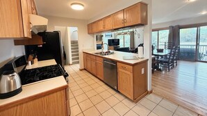 Una cocina moderna con armarios de madera, estufa de acero inoxidable y lavavajillas.
