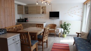 Een knus woongedeelte met een eethoek, kitchenette en zithoek.