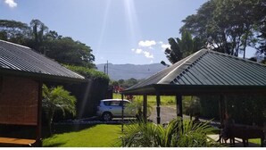 Um bairro residencial com um carro na entrada, uma área de estar coberta ao ar livre e uma casa com telhado inclinado.