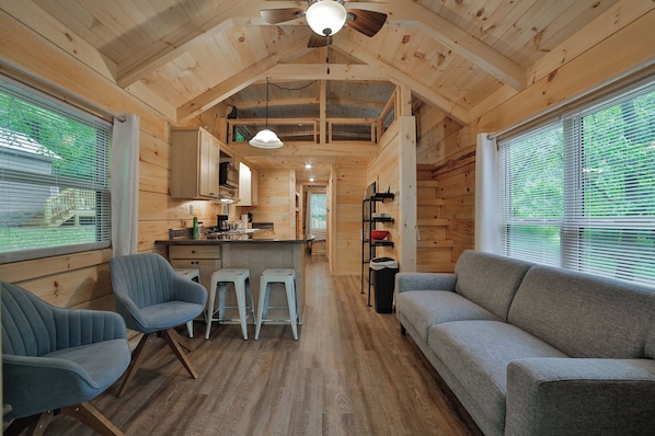 A cabin interior with a kitchen, dining area, and seating.