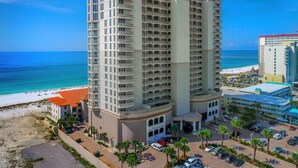 Ein Hochhaus-Hotel mit mehreren Balkonen mit Blick auf einen Strand.