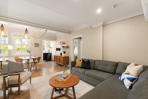 A spacious living area with a sofa, coffee table, and dining setup.