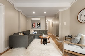A living room with a sectional sofa, a round coffee table, and a side table.