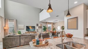 A modern kitchen with granite countertops, a stainless steel sink, and pendant lighting. - 5BD/5BA Gorgeous Home w/ pool close to Disney (Kissimmee)