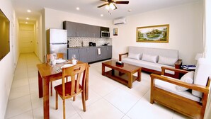 A compact living space with a kitchenette, dining area, and a sofa.