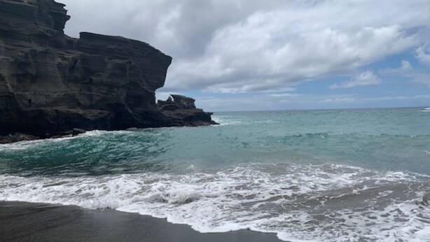 A beach with dark sand and a rocky cliff. - #41 Turtle Hut at Punalu`u Black Sand Beach * Most (Pahala)