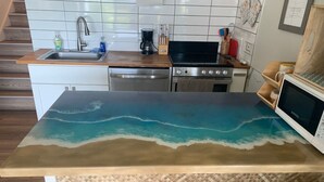 A kitchen with a wooden countertop, stainless steel appliances, and a tiled backsplash. - #41 Turtle Hut at Punalu`u Black Sand Beach * Most (Pahala)