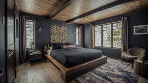 Une chambre à coucher avec un grand lit, des poutres en bois et de grandes fenêtres.