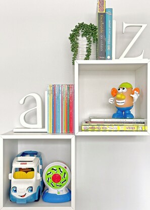 Ein Bücherregal mit Büchern, einem Spielzeugauto und einer Spielfigur.