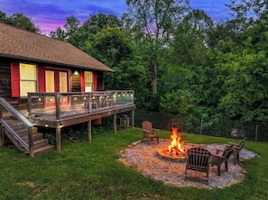 Une cabane en bois dotée d’une terrasse, d’un foyer extérieur et de sièges pour profiter de l’extérieur.