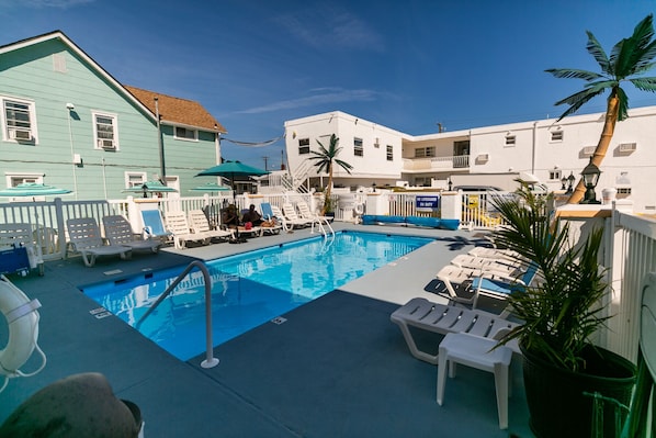 Relax by the pool surrounded by comfortable lounge chairs and shaded by umbrellas.