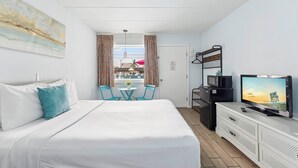 Hotellihuone, jossa on sänky, televisio, työpöytä ja näkymä ulos.