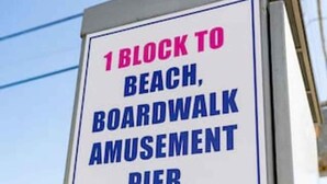 A directional sign indicating '1 block to beach, boardwalk, amusement, pier & food' with an arrow pointing left. - Daytona Inn and Suites - Efficiency Queen (Wildwood)