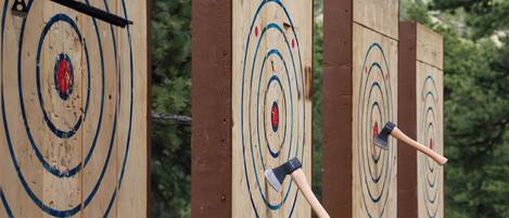 A wooden archery target with concentric circles and arrows embedded in the center.