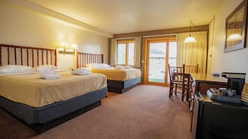 Een hotelkamer met twee bedden, een bureau en een stoel.