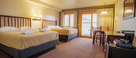 Een hotelkamer met twee bedden, een bureau en een stoel.