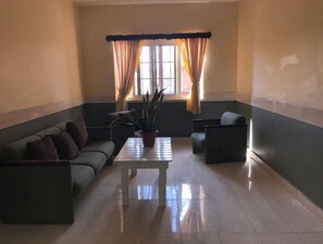 Relax in a spacious room with a large window, seating area, and potted plant.
