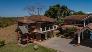 Uma casa moderna com dois andares, um pátio espaçoso, grandes janelas e um gramado bem cuidado.