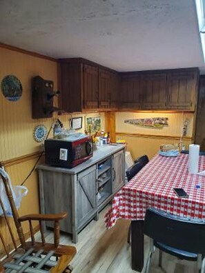 Compact kitchen area with a table and chair for dining or meal prep.