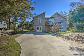 A two-story house with a front porch, a staircase to the upper floor, and a small deck.