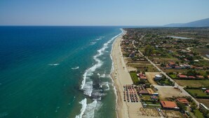 Vista aérea de un pueblo costero con playa, casas y un río.