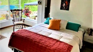 Ein Schlafzimmer mit einem Bett, einem Sessel und einem Fenster.