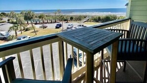 Ein Balkon mit Blick auf Strand und Meer.