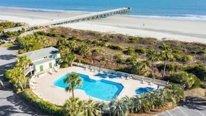 Ein Strandhotel mit Schwimmbad, einer Pier und dem Strand.