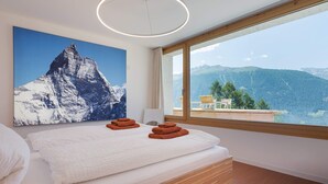 A bedroom with a large bed, a mountain view, and a painting of a mountain. - Exclusive architectural chalet at 1,600 metres, 4-6 pers. in impressive location (Suen)