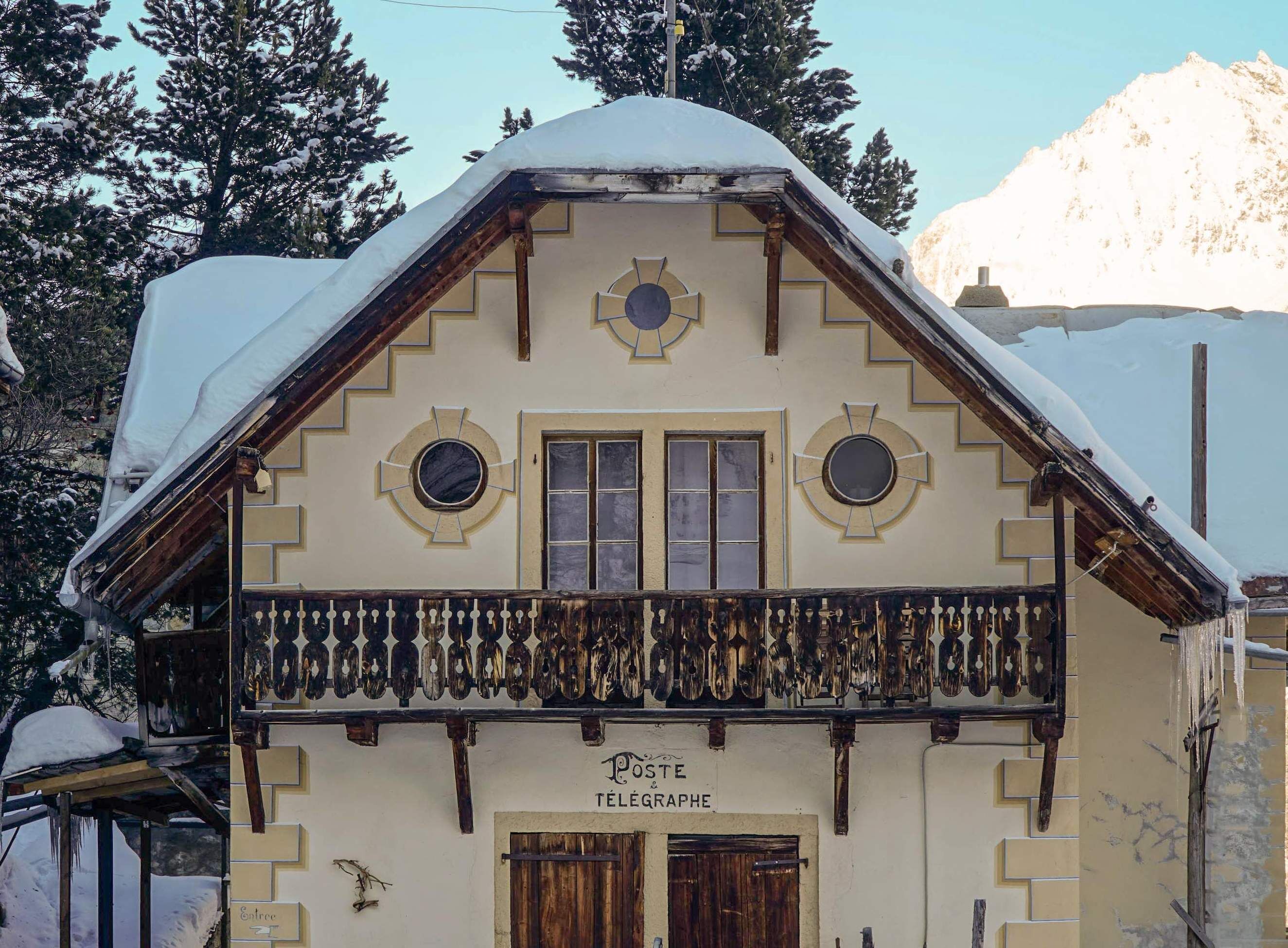 A building with a traditional facade, a balcony with hanging bells, and a sign reading "Poste & Télégraphe".