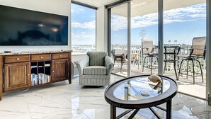 A spacious balcony with a large TV, a comfortable chair, and a glass table. - Welcome to the paradises 
Departure clean included. Adv. #034724w10370b (Fort Myers Beach)