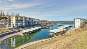 Un puerto deportivo con varios muelles y barcos, rodeado de edificios modernos con balcones.