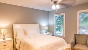 A bedroom with a bed, nightstands, a chair, and a ceiling fan. - Suite 104 in Madison.... “Stay Awhile” (Madison)