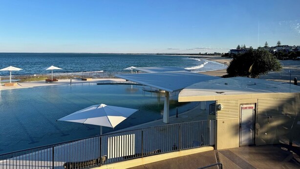Ein Poolbereich mit Blick aufs Meer, ein überdachter Sitzbereich und ein Gebäude mit der Aufschrift 'PLANT ROOM'.