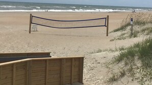 En strand med en träpromenad som leder till strandens ingång.