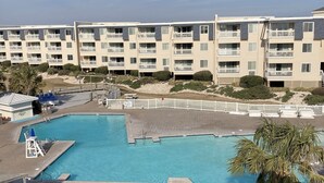 Ett hotell med flera våningar, en swimmingpool och ett område vid stranden.