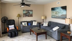 A living room with a ceiling fan, two sofas, a coffee table, a massage chair, and two lamps. - Kona Ocean View:  Beautifully Furnished, Amazing View, White Sands Beach (Kailua-Kona)
