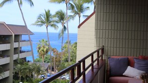 A balcony with a view of the ocean and palm trees. - Kona Ocean View:  Beautifully Furnished, Amazing View, White Sands Beach (Kailua-Kona)