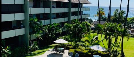 A hotel with a pool, outdoor seating, and a view of the ocean.